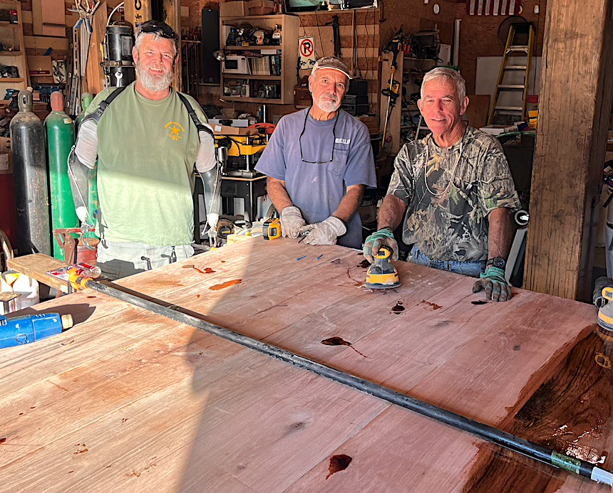 Dave, Robert, and David work on a large table